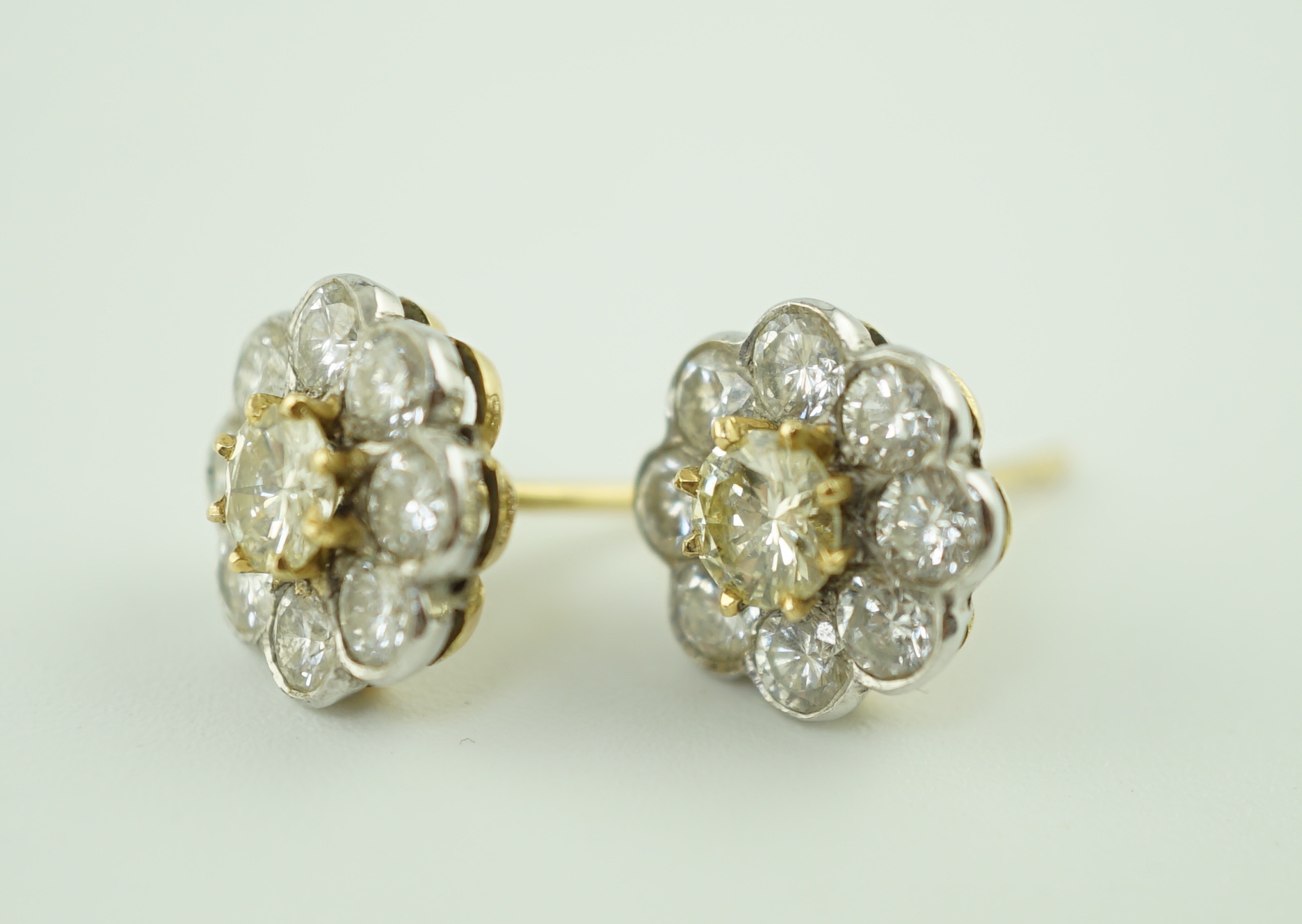 A pair of gold and nine stone diamond cluster set flower head ear studs